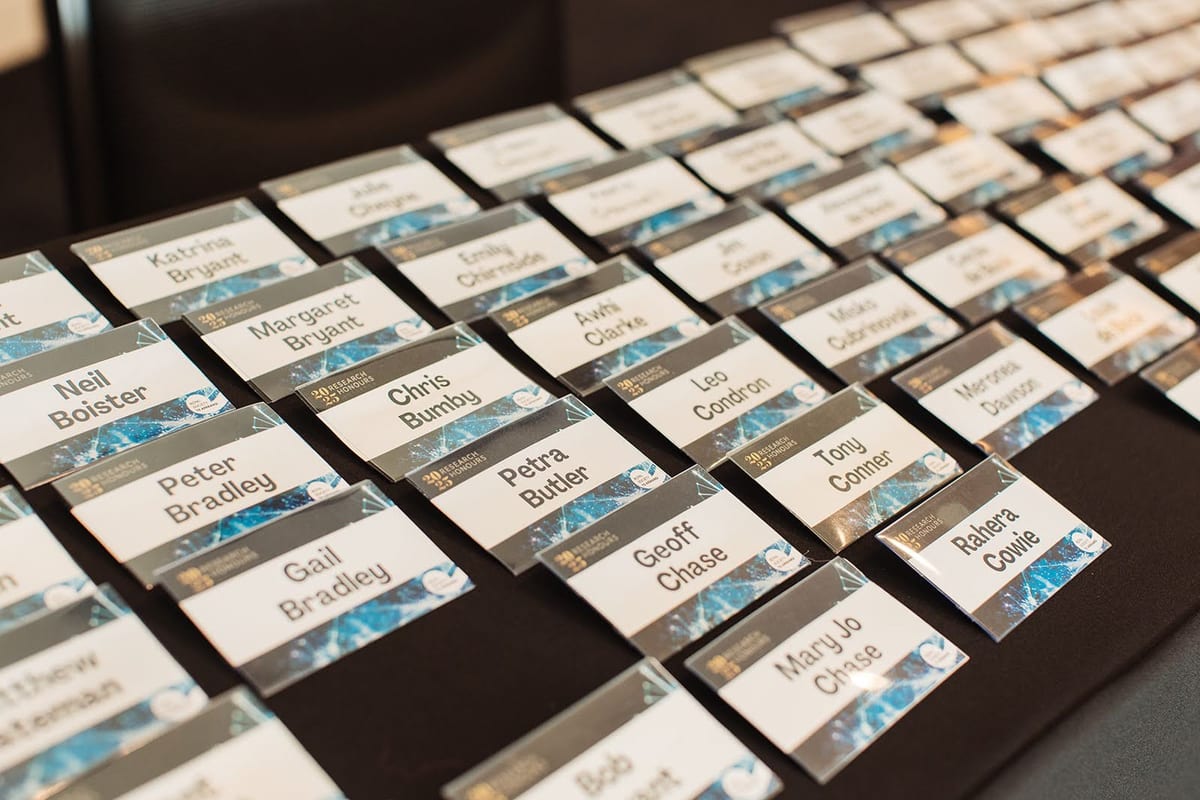 Rows of printed name badges laid out in order on a registration table before a conference opens